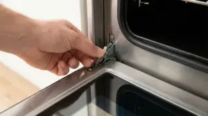 Mano che regola una manopola interna dello sportello del forno aperto