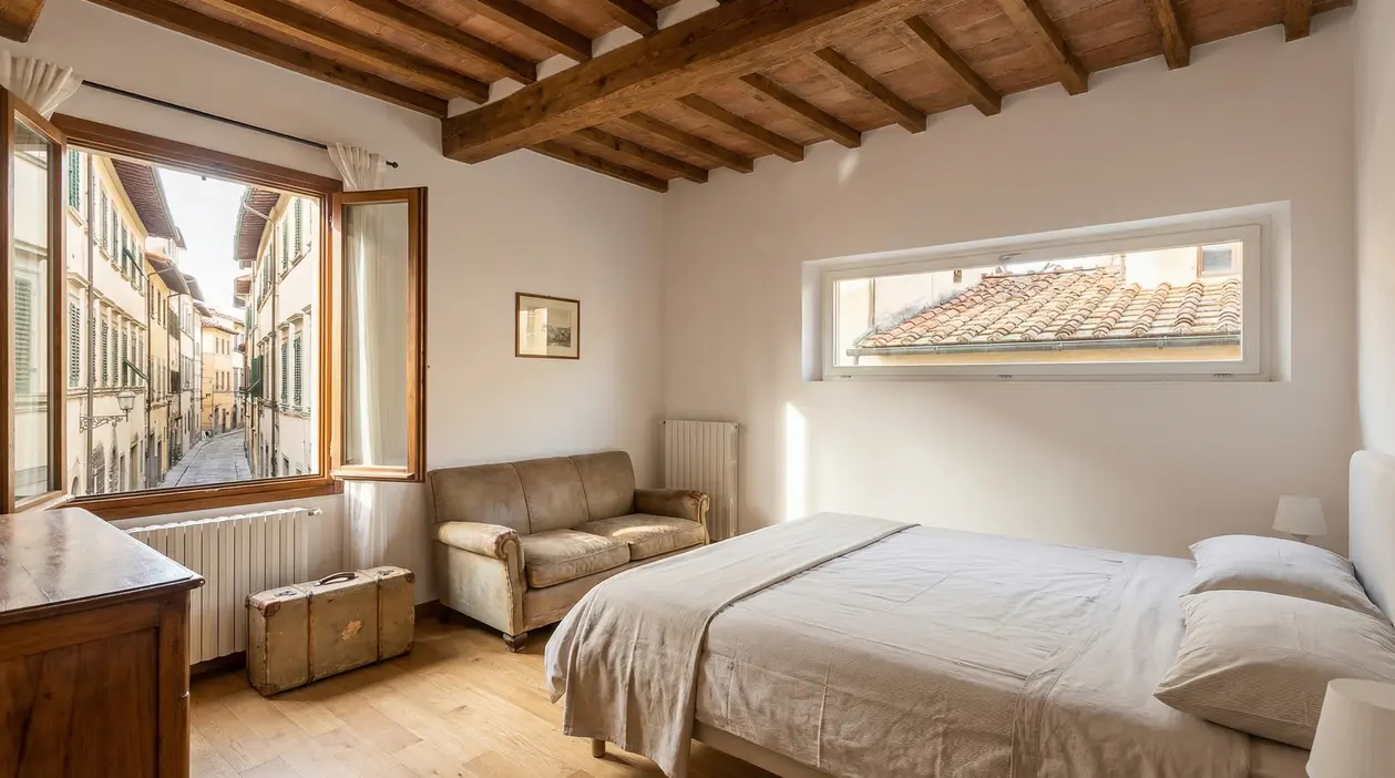 Camera da letto luminosa con vista su una strada del centro storico di Firenze