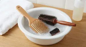 Spazzole per capelli immerse in acqua saponata in una bacinella per la pulizia domestica