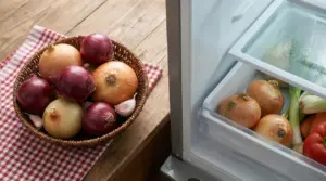 Cipolle in un cestino su un tavolo accanto a cipolle conservate in un frigorifero