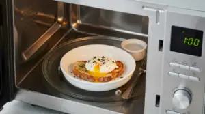 Uovo in camicia servito su pane tostato dentro un forno a microonde