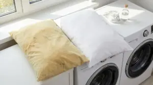 Due federe su una lavatrice, una ingiallita dal sudore e una bianca dopo il lavaggio