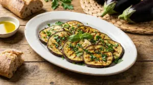 Fette di melanzane grigliate con prezzemolo su piatto bianco, con pane e olio d'oliva accanto