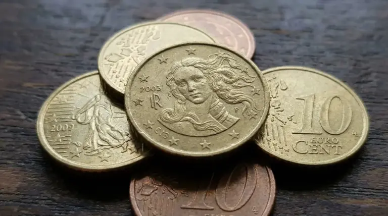 Monete da 10 centesimi di euro sparse su una superficie in legno