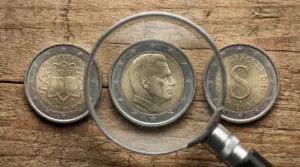 Tre monete da 2 euro su legno, una vista attraverso una lente d'ingrandimento