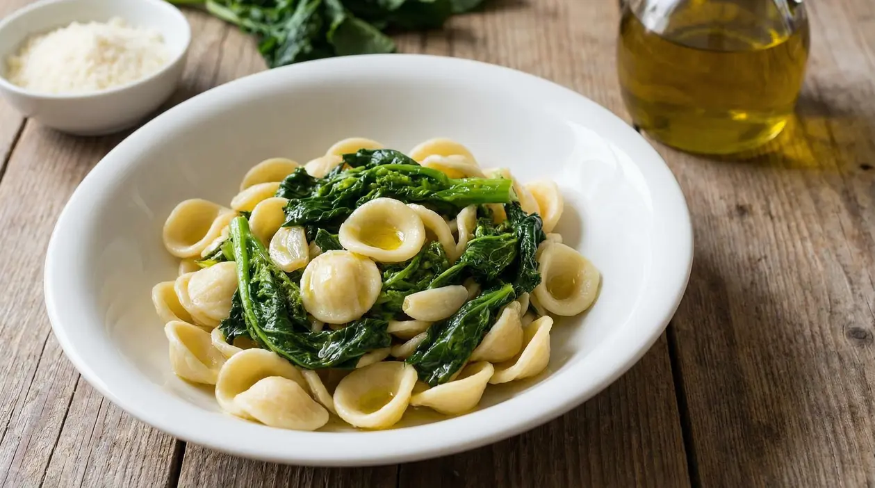 Piatto di orecchiette con cime di rapa su tavolo di legno