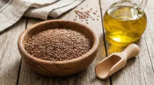 Ciotola di semi di lino con olio in bottiglia su tavolo di legno