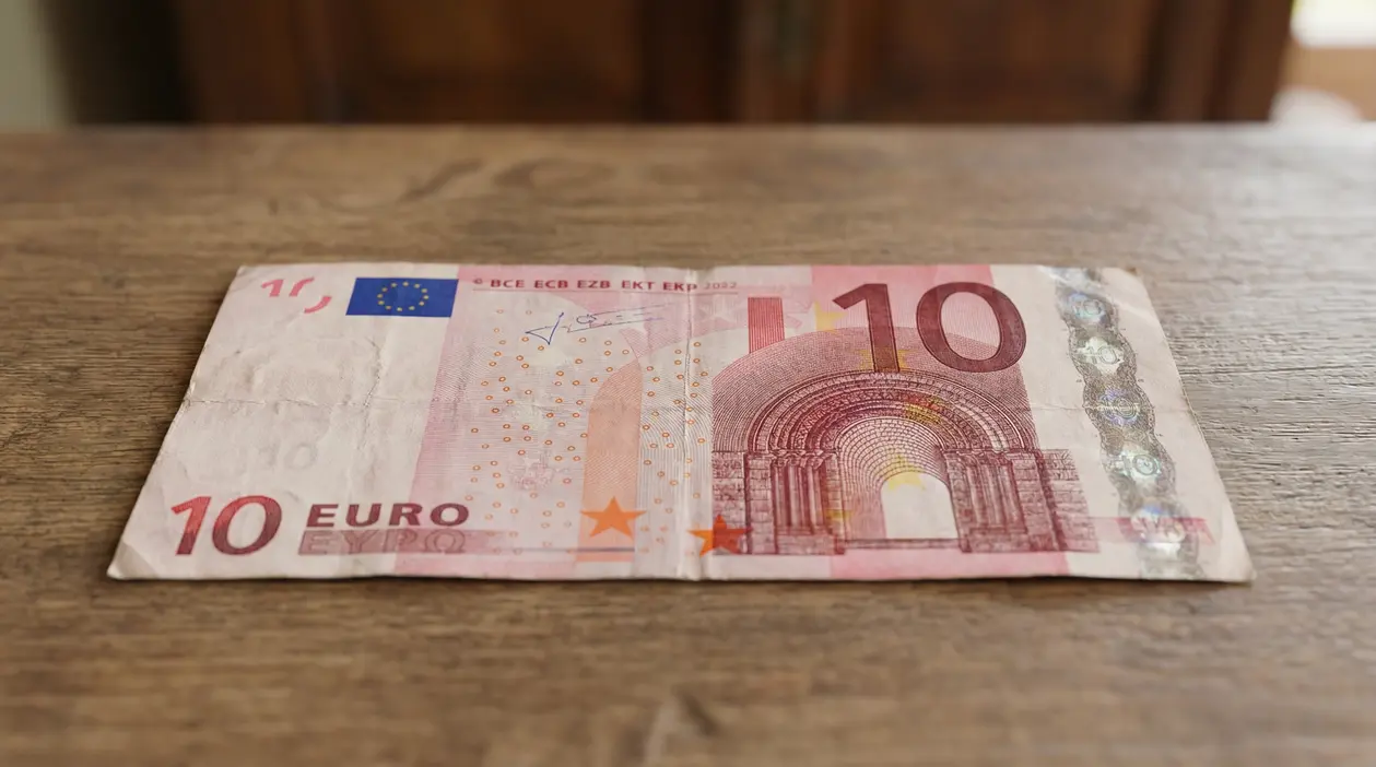 Vecchia banconota da 10 euro leggermente usurata su superficie in legno